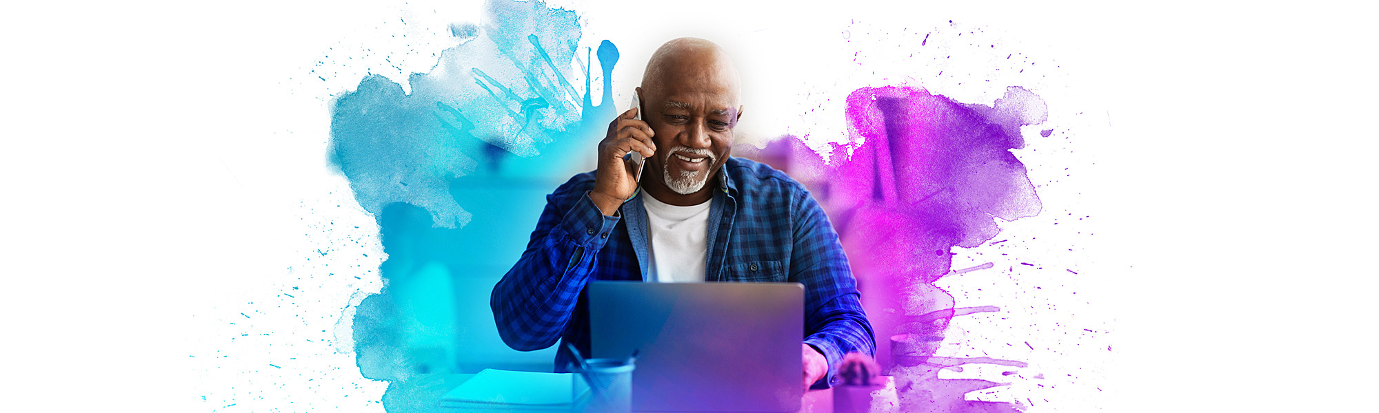 Senior male on the phone while viewing the Brethren Village website on a laptop