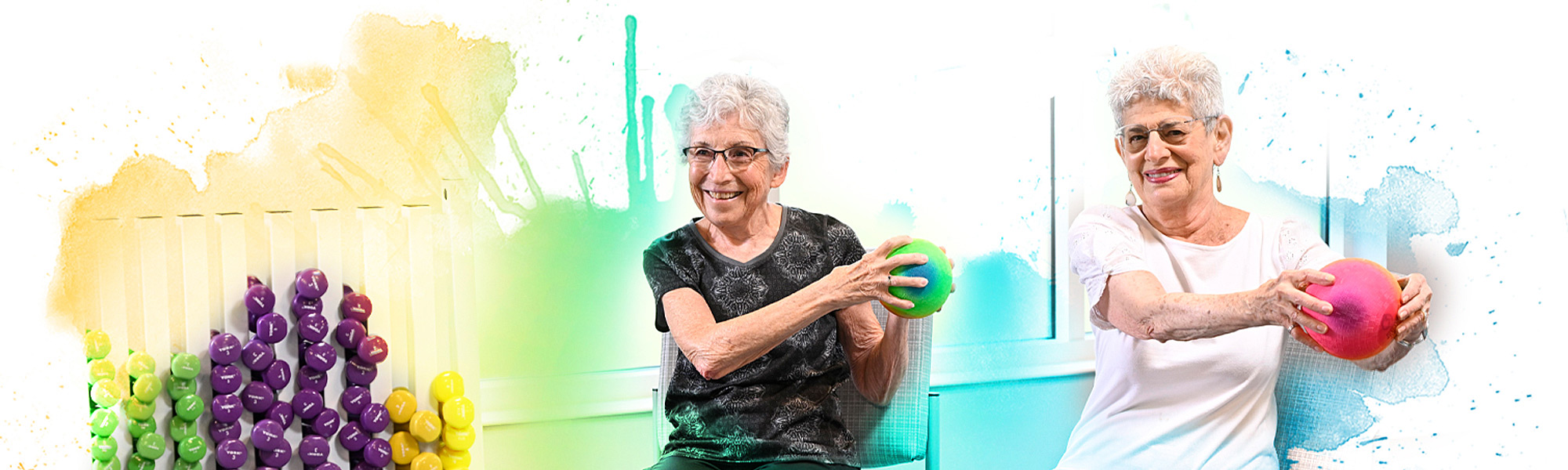 Two female residents participating in an exercise wellness chair class